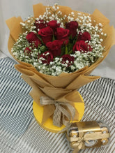 A beautiful bouquet of long-stemmed red roses with baby breath fillers accompanied by a box of Ferrero Rocher chocolates. 